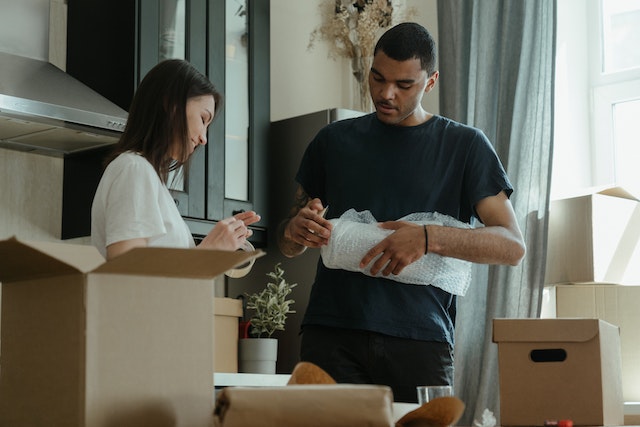 people unpacking boxes in a kitchen