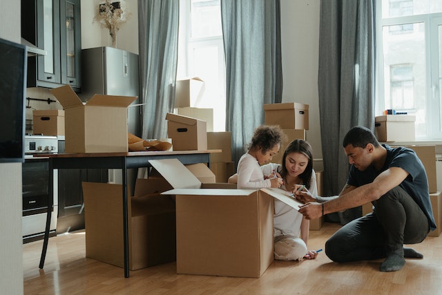 family in kitchen surrounded by moving boxes