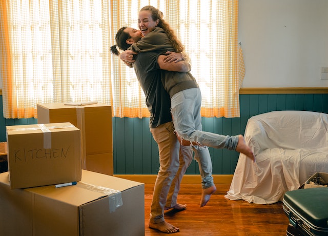 couple hugging in a room with moving boxes