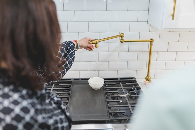 person inspecting a golden faucet